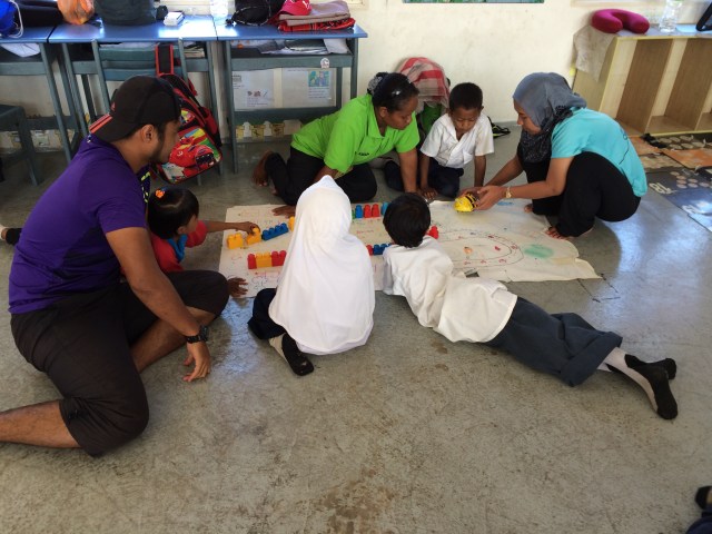 A parent (in green t-shirt) engaging in a Grade 1-2 class 
